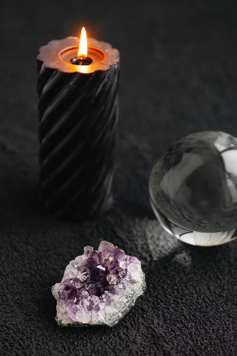 Crystal ritual candle flat lay with feathers